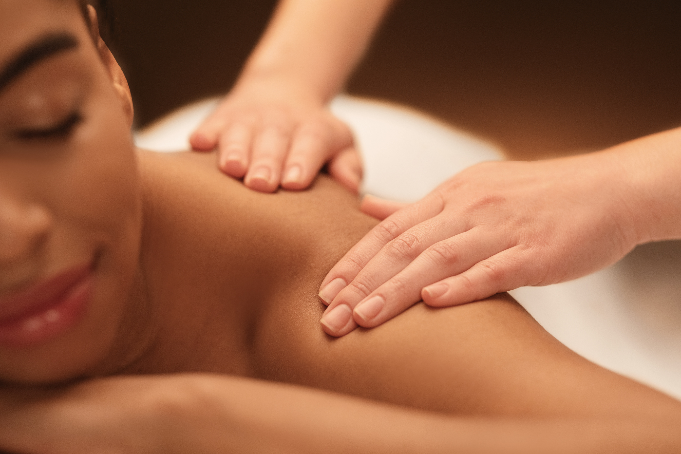 Masseuse hands massaging african woman shoulders, relaxing body massage
